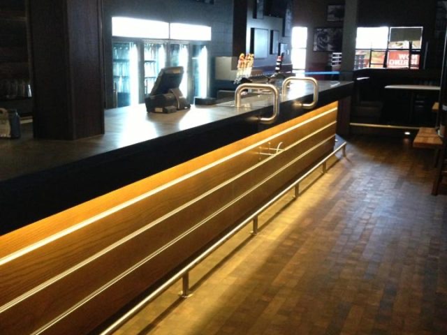 Finished bar face wrapped in wood planks with lit reveal lines
