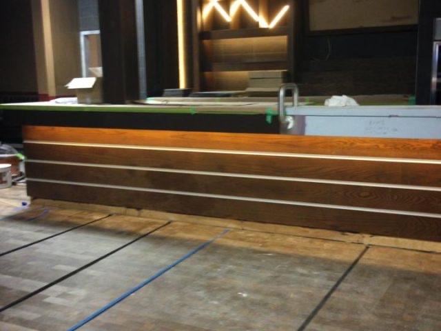 Bar face mid-build with wood planks and protective coverings