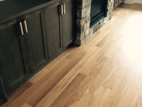 Dark cabinets and stone detail over light hardwood flooring