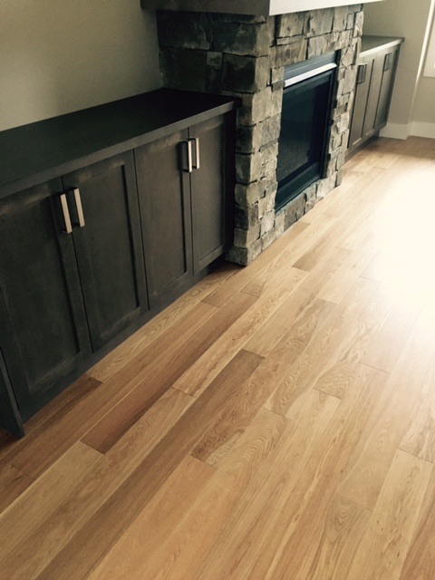Dark plank flooring beside red banquette seating