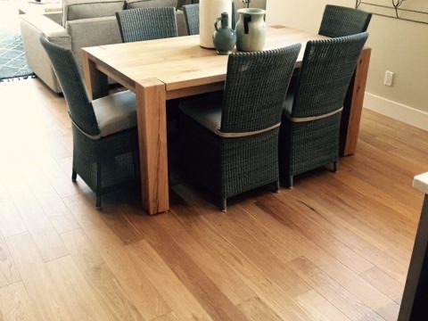 Dining table with wicker chairs on oak flooring